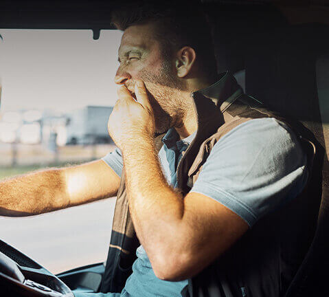 Homem boceja enquanto conduz